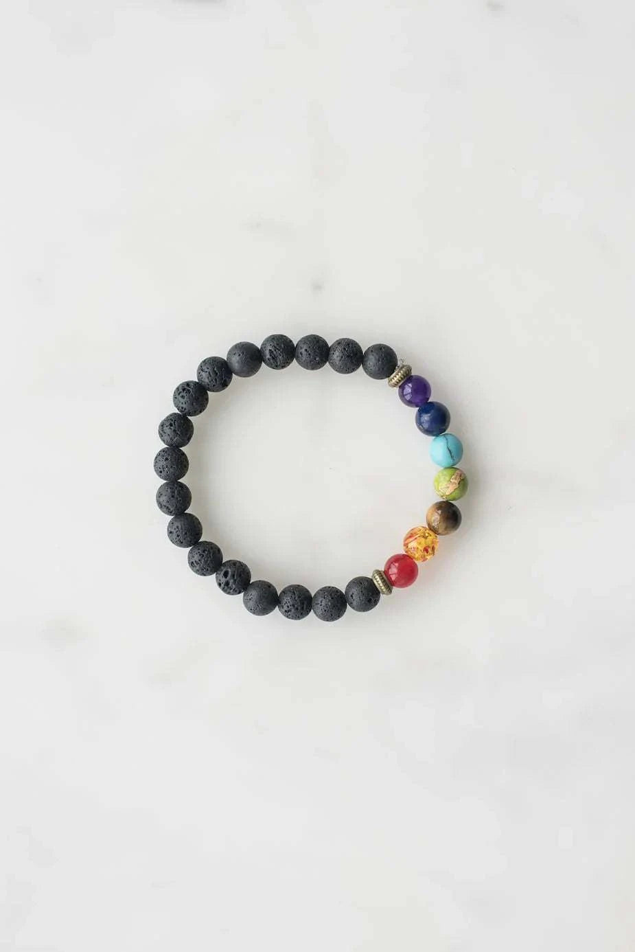7 chakra bracelet with black lava beads and colorful chakra stones on white background