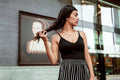 Woman wearing black cotton top with a matching striped skirt outdoors, striped skirt and top set